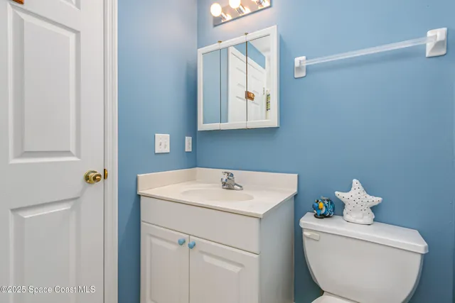 a bathroom with a sink mirror and toilet