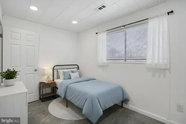 a bedroom with a bed and a potted plant