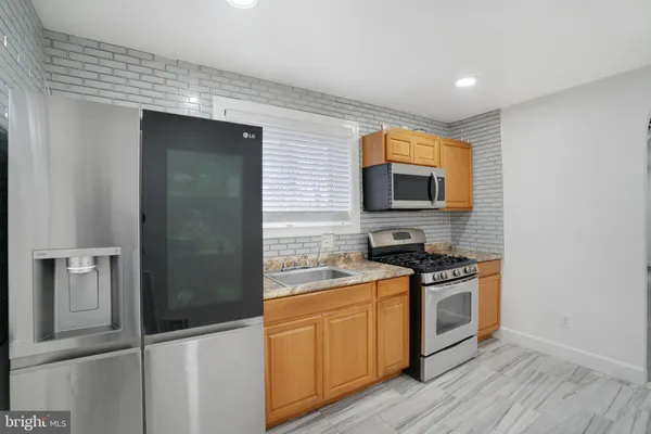 a kitchen with stainless steel appliances granite countertop a stove a sink and a refrigerator