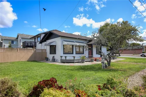 a view of a house with a yard and sitting area