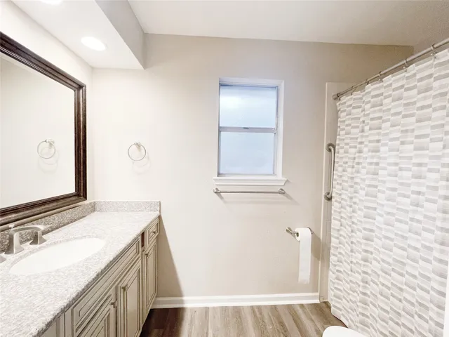 a bathroom with a granite countertop sink a mirror and a shower