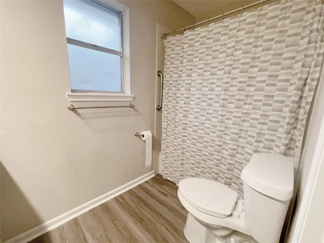 a white toilet sitting next to a shower curtain