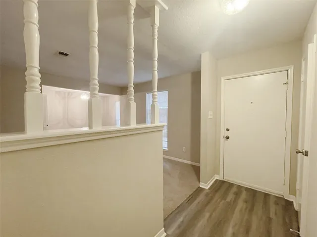 view of an empty room with wooden floor and a window