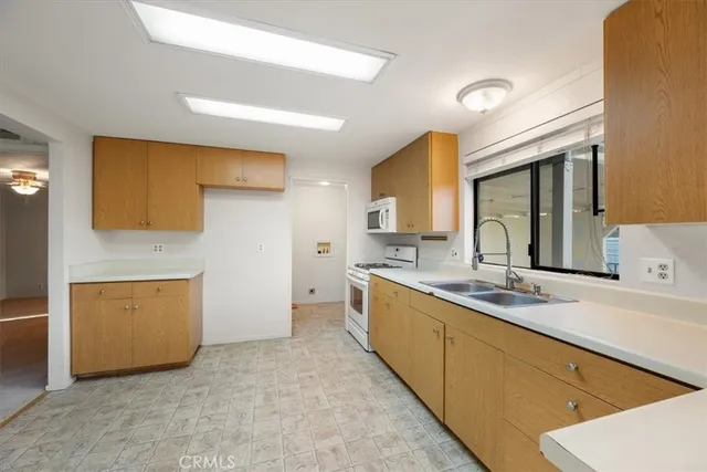 a large kitchen with stainless steel appliances a stove a sink and a refrigerator