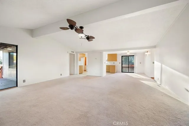 a view of a room with chandelier fan and windows