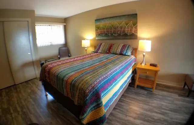 a bedroom with a bed and wooden floor