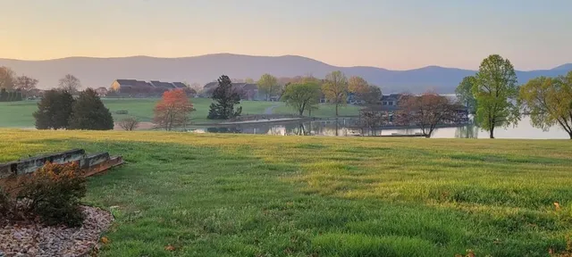 a view of a lake with sunset in background