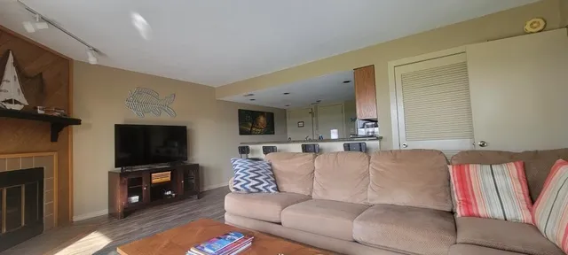 a living room with furniture a flat screen tv and a fireplace