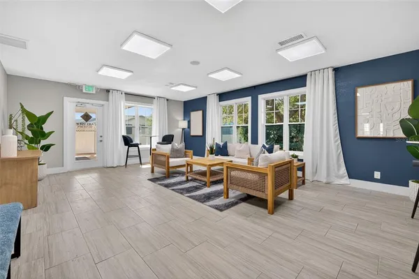 a living room with furniture and large windows