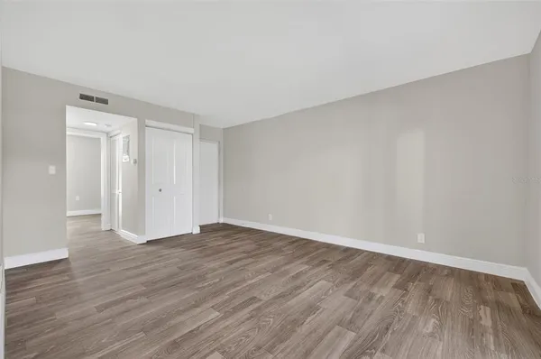 a view of an empty room with wooden floor