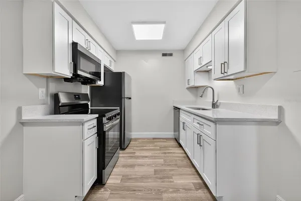 a kitchen with stainless steel appliances a sink stove and cabinets