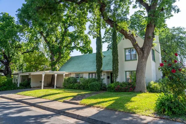a front view of a house with a yard and trees