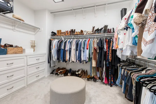 a view of walk in closet with clothes and shoes