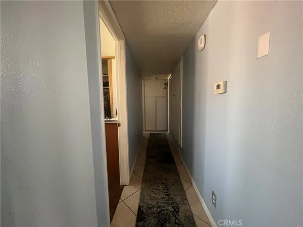 a view of a hallway with wooden floor and a bathroom