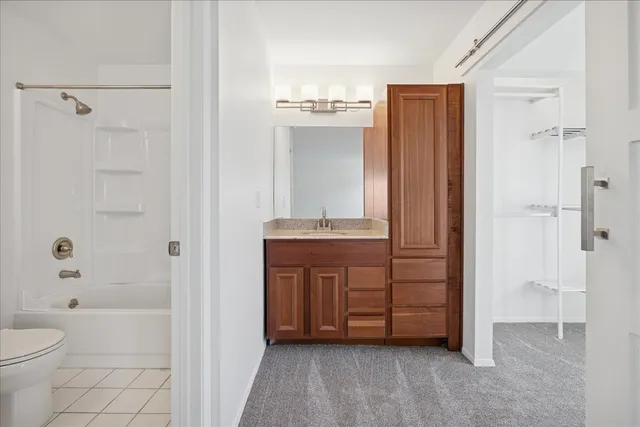 a bathroom with a granite countertop sink a toilet and shower
