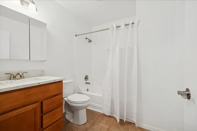 a bathroom with a toilet sink vanity and tub