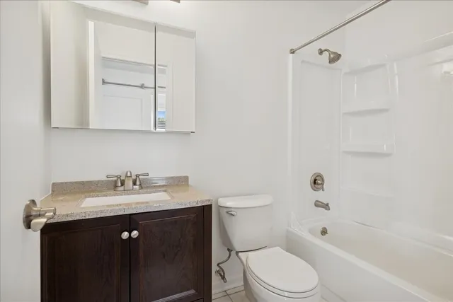a bathroom with a sink toilet vanity and shower