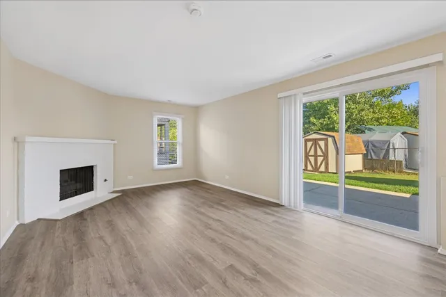 an empty room with floor to ceiling windows and wooden floor