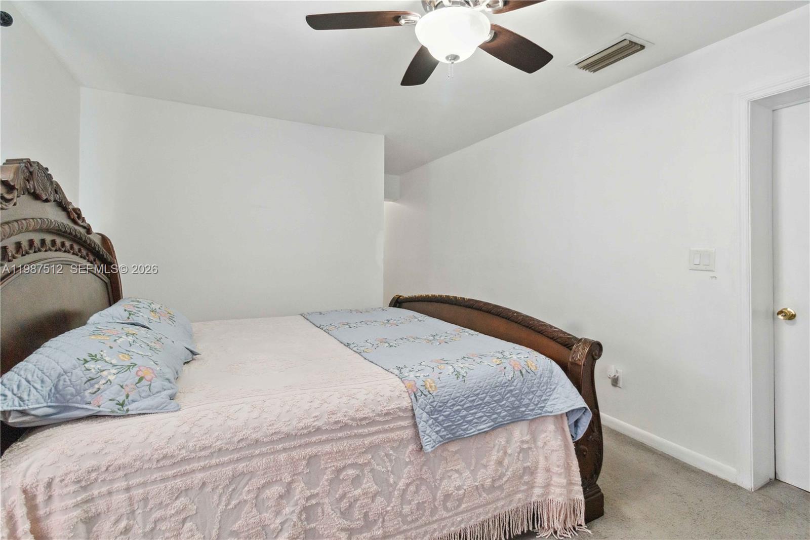 14461 Southwest 285th Street Homestead, FL 33033 - Photo 13 of 17 a bedroom with a bed and a chandelier