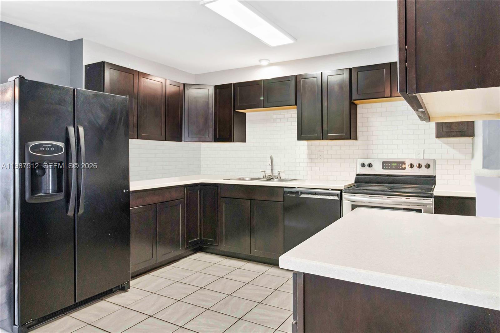 14461 Southwest 285th Street Homestead, FL 33033 - Photo 8 of 17 a kitchen with stainless steel appliances a sink and a refrigerator