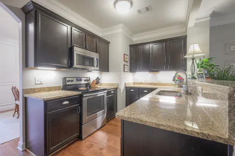 a kitchen with stainless steel appliances granite countertop a sink stove and oven