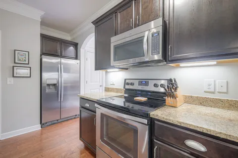 a kitchen with granite countertop a sink and stainless steel appliances