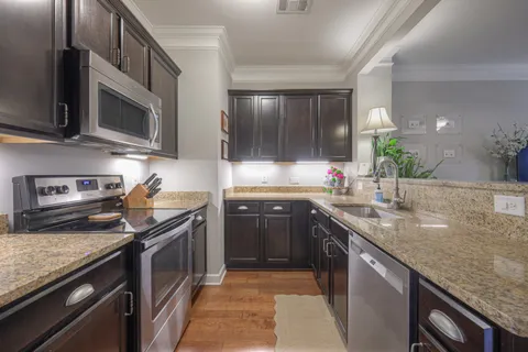 a kitchen with stainless steel appliances granite countertop a sink stove and oven