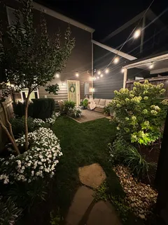 a patio with table and chairs and potted plants