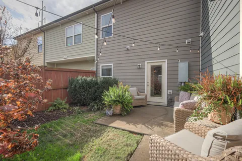 a view of a chair and table in backyard of the house