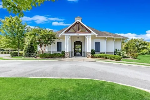 a view of a house and a yard with large trees