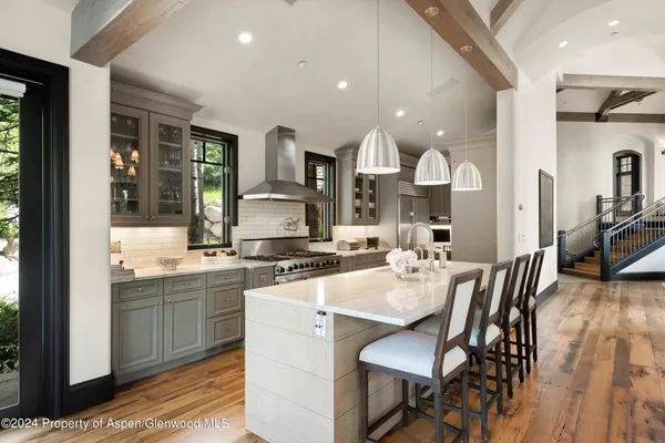 a kitchen with a sink and chairs