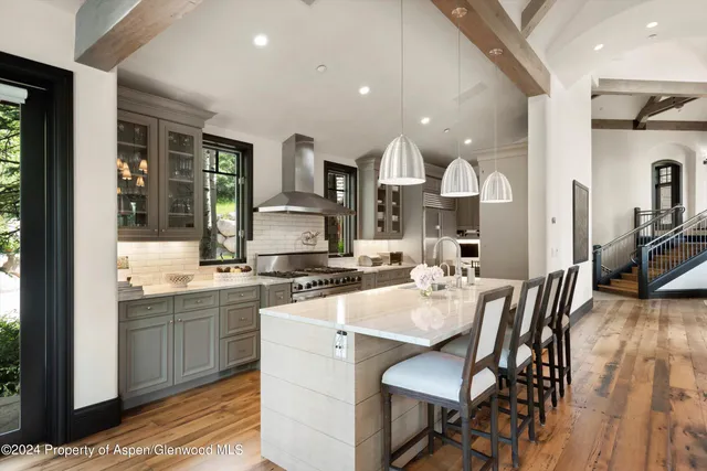 a kitchen with a sink and chairs