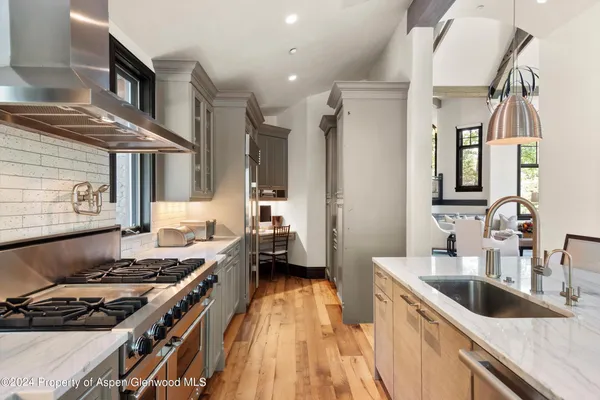 a view of a dining room with furniture a chandelier and wooden floor
