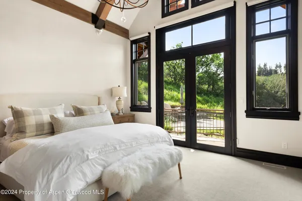 a bathroom with a double vanity sink large mirror and a large window