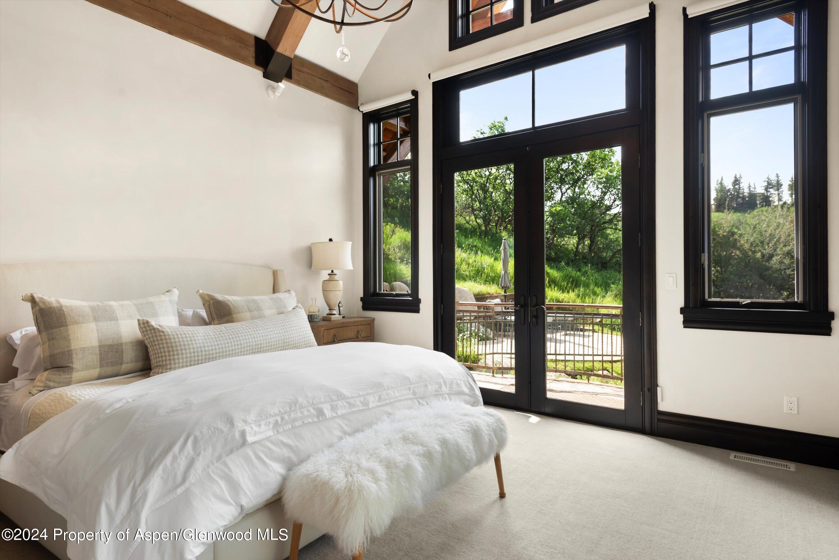 27 Nighthawk Drive Aspen, CO 81611 - Photo 19 of 61 a bed sitting in a bedroom next to a large window