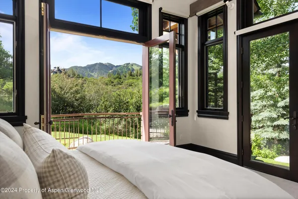 a living room with furniture potted plant and a large window