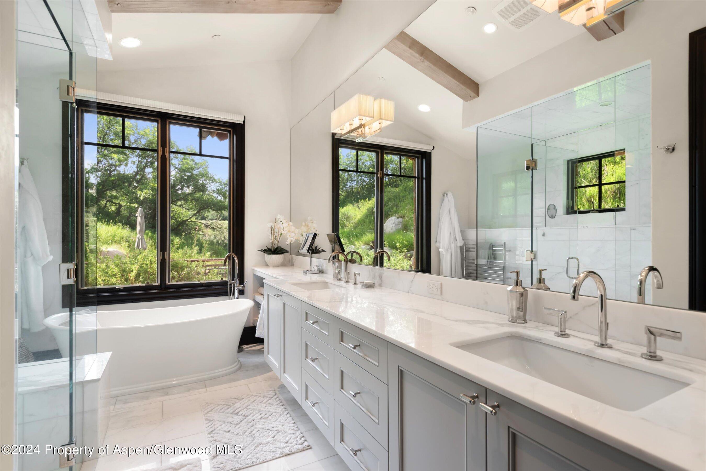 27 Nighthawk Drive Aspen, CO 81611 - Photo 22 of 61 a bathroom with a double vanity sink large mirror and a large window