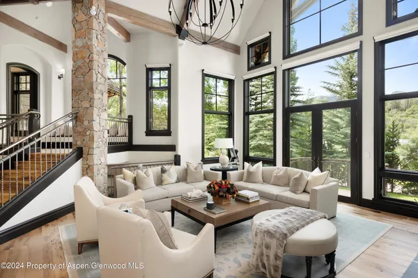 a living room with furniture and floor to ceiling windows