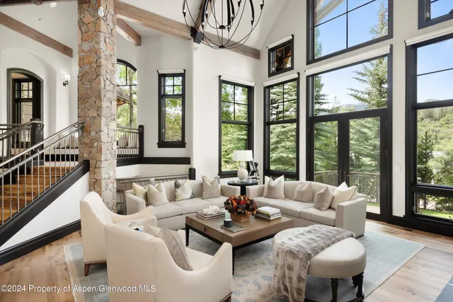 a living room with furniture and floor to ceiling windows