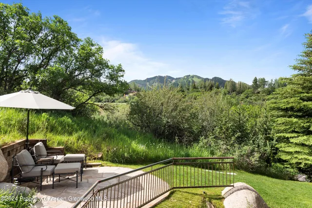 an aerial view of a houses with a lush green hillside