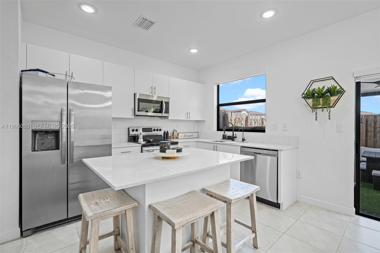9941 Southwest 231st Lane, Unit 9941 Miami, FL 33190 - Photo 1 of 29 a kitchen with kitchen island a counter top space appliances and cabinets