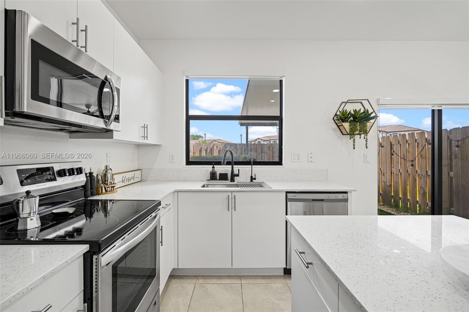 9941 Southwest 231st Lane, Unit 9941 Miami, FL 33190 - Photo 11 of 29 a kitchen with a sink stove and microwave