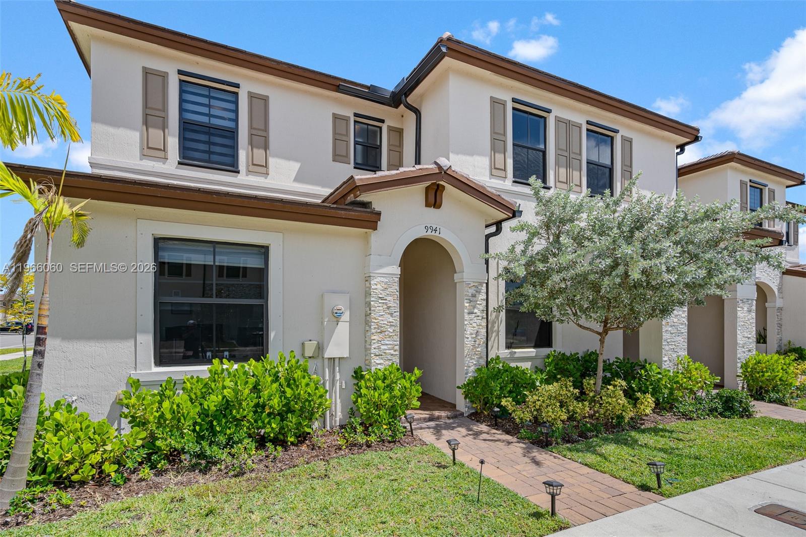 9941 Southwest 231st Lane, Unit 9941 Miami, FL 33190 - Photo 2 of 29 a front view of a house with garden