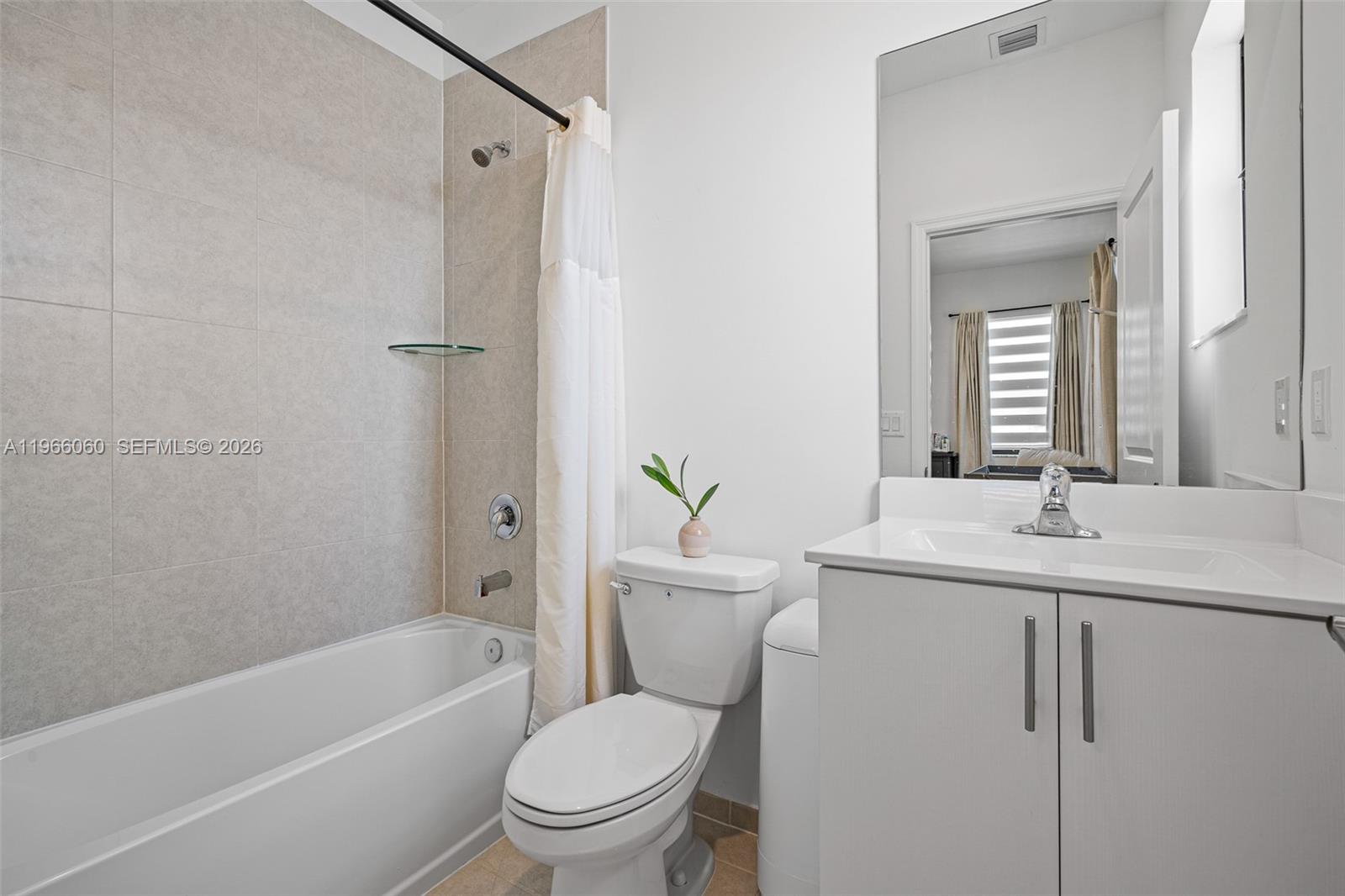 9941 Southwest 231st Lane, Unit 9941 Miami, FL 33190 - Photo 23 of 29 a bathroom with a granite countertop toilet a sink and a bathtub