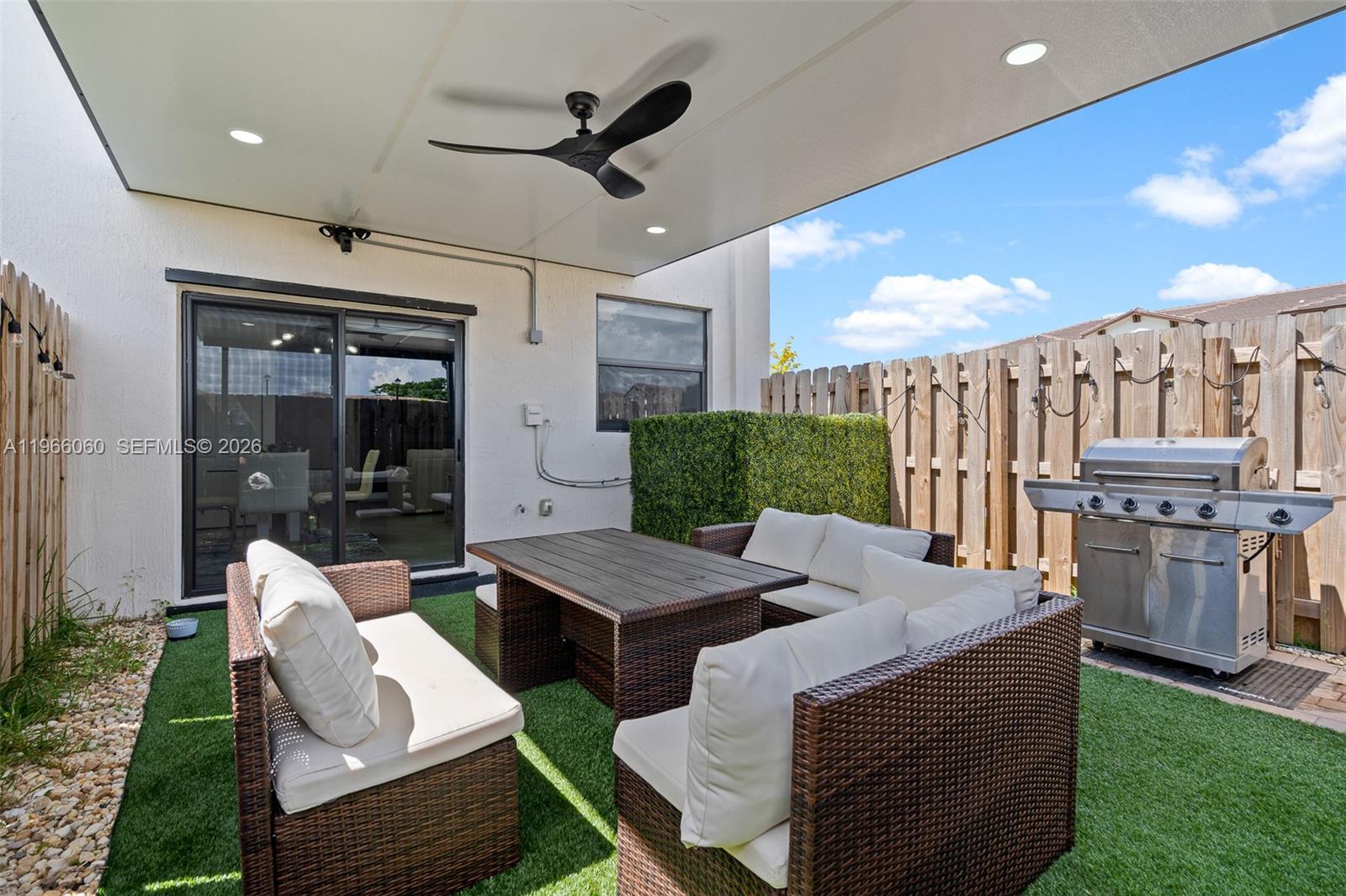 9941 Southwest 231st Lane, Unit 9941 Miami, FL 33190 - Photo 28 of 29 a outdoor space with patio the couches and a dining table with the garden view