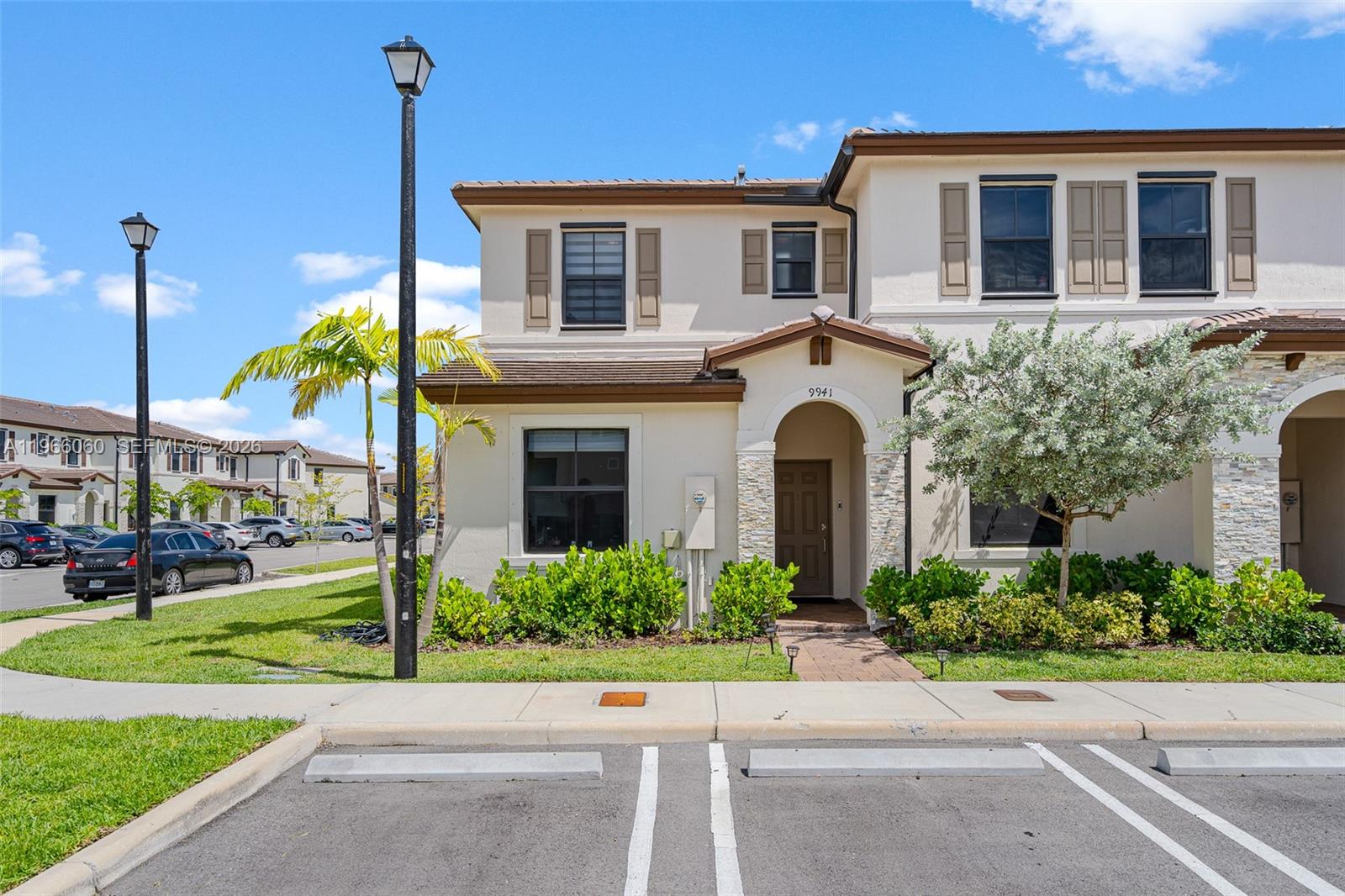 9941 Southwest 231st Lane, Unit 9941 Miami, FL 33190 - Photo 3 of 29 a front view of a house with a garden and trees