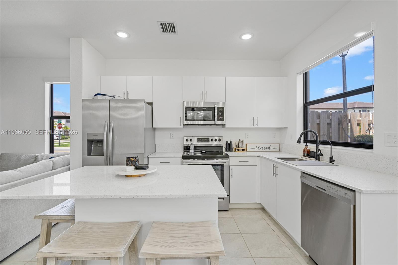9941 Southwest 231st Lane, Unit 9941 Miami, FL 33190 - Photo 9 of 29 a kitchen with stainless steel appliances a sink a stove a refrigerator cabinets and a counter top space