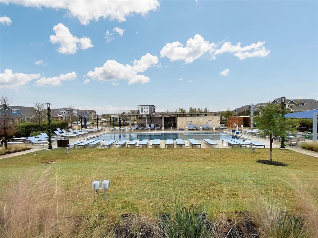 8901 Panhandle Drive Austin, TX 78747 - Photo 21 of 21 Expansive community pool area featuring a large swimming pool, numerous lounge chairs, and a shaded pergola structure