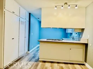 a kitchen with a sink a stove wooden floor and cabinets