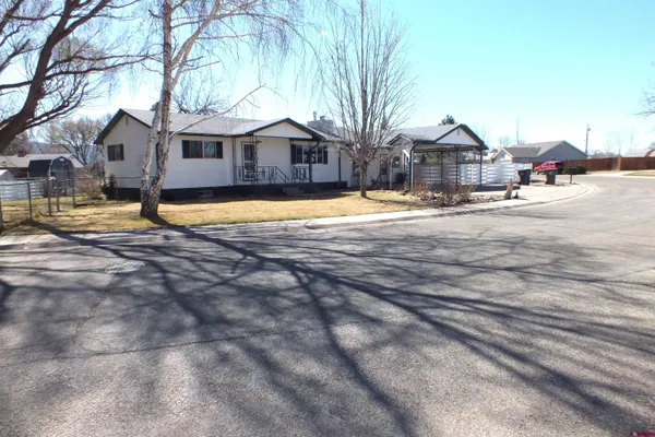 a front view of a house with a yard covered in snow
